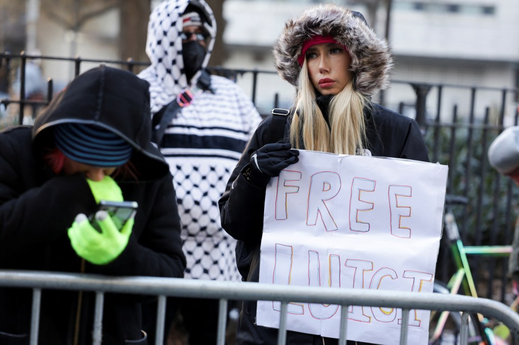 A woman holding a 'Free Luigi' placard outside New York Supreme Court during arraignment hearing for Luigi Mangione, murder suspect of UnitedHealth CEO Brian Thompson