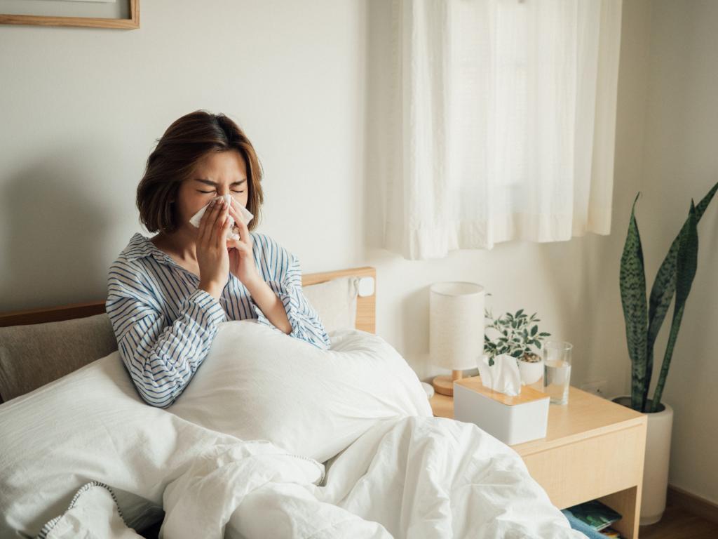 Outpatient visits for flulike illness were noticeably higher last week in California, Oregon, Arizona, Louisiana, New Jersey and the District of Columbia, CIDRAP reported. Here, a woman blows her nose in bed. A runny nose is a flu symptom.