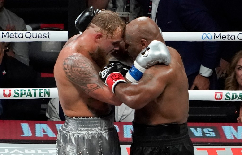 US YouTuber/boxer Jake Paul (L) and US retired pro-boxer Mike Tyson (R) hug at the end of their heavyweight boxing bout at The Pavilion at AT&T Stadium in Arlington, Texas, November 15, 2024.