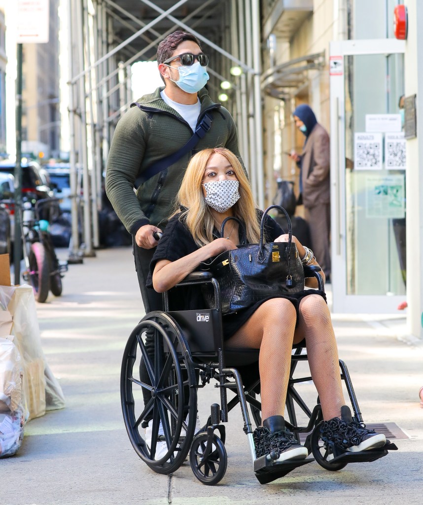 Wendy Williams being pushed in a wheelchair