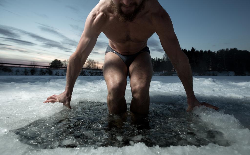 Willpower goes hand-in-hand with passion and a particular mindset, the researchers found. Here, a man lowers himself into an ice hole for a swim.