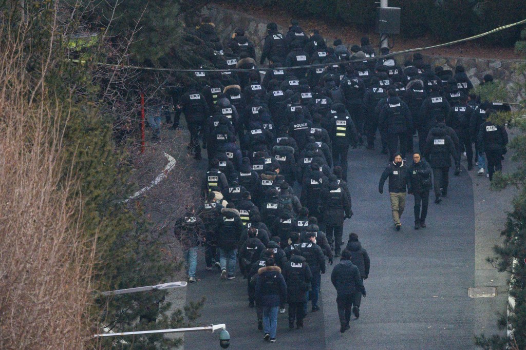 Police officers enter the compound of the presidential residence of impeached South Korea President Yoon Suk Yeol in Seoul on January 15, 2025