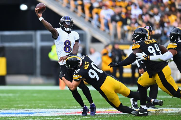 Lamar Jackson #8 of the Baltimore Ravens attempts pass while being hit by T.J. Watt #90 of the Pittsburgh Steelers in the third quarter of a game at Acrisure Stadium on November 17, 2024 in Pittsburgh, Pennsylvania.