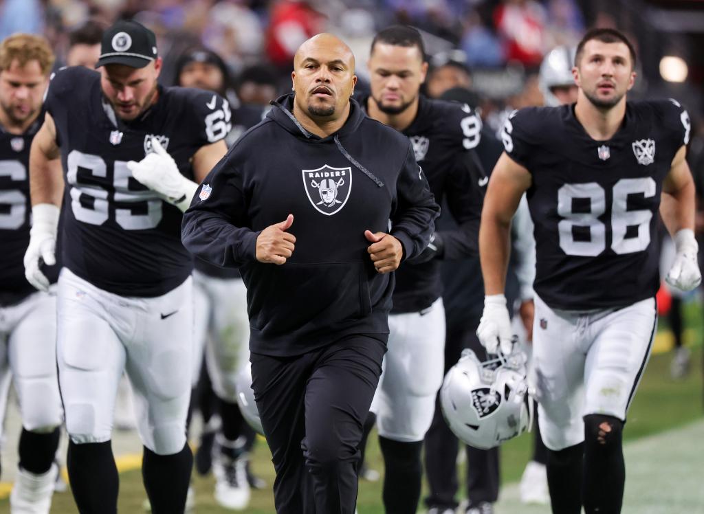 Head coach Antonio Pierce and his Raiders players leave the field at halftime of a game against the Los Angeles Chargers.