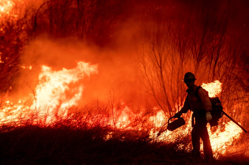 A firefighter sets a backburn in front of the advancing Kenneth Fire in the West Hills section of Los Angeles, Thursday, Jan. 9, 2025.