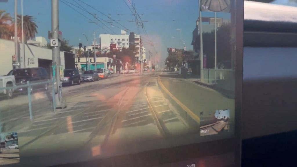 A screengrab from the video shows the Tesla driving over train tracks.