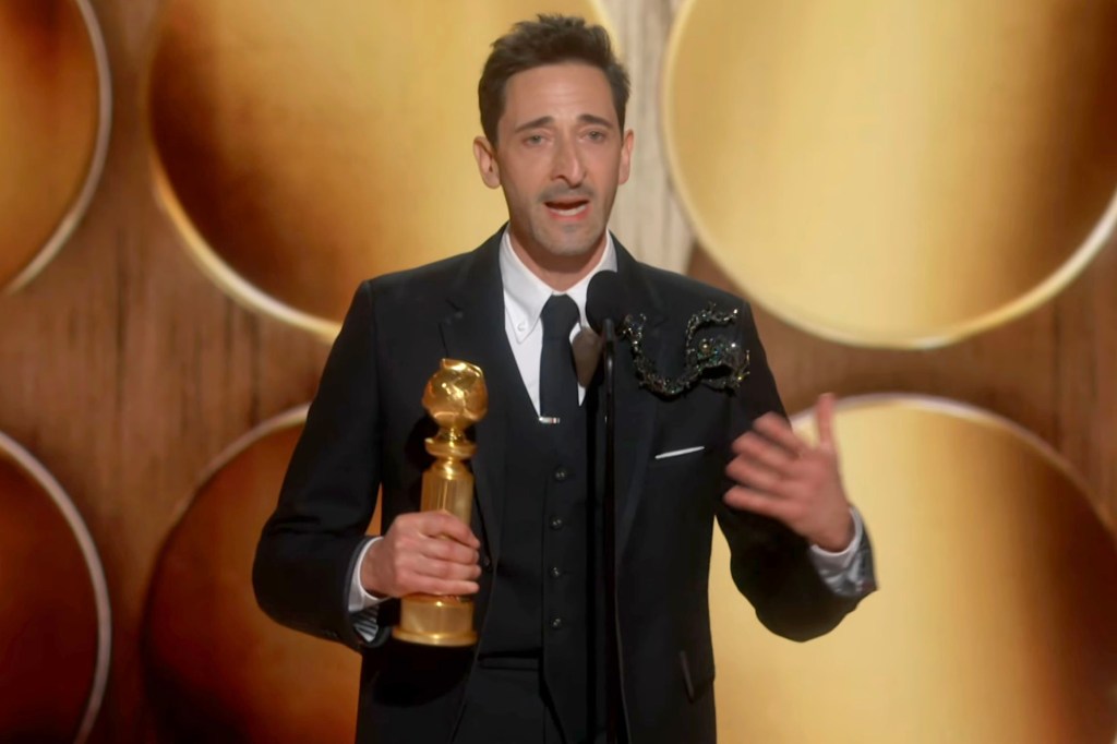 Adrien Brody holding a globe