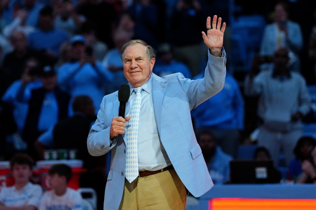 Bill Belichick waves to the crowd at a North Carolina basketball game.