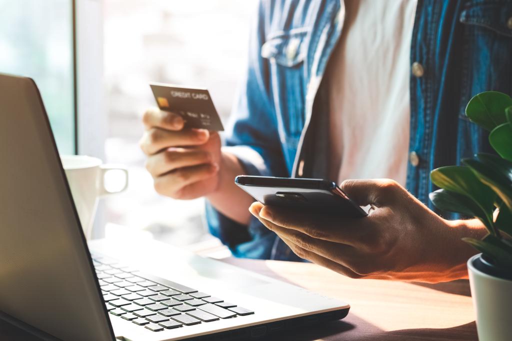 Man making online purchases using credit card and mobile banking app on phone