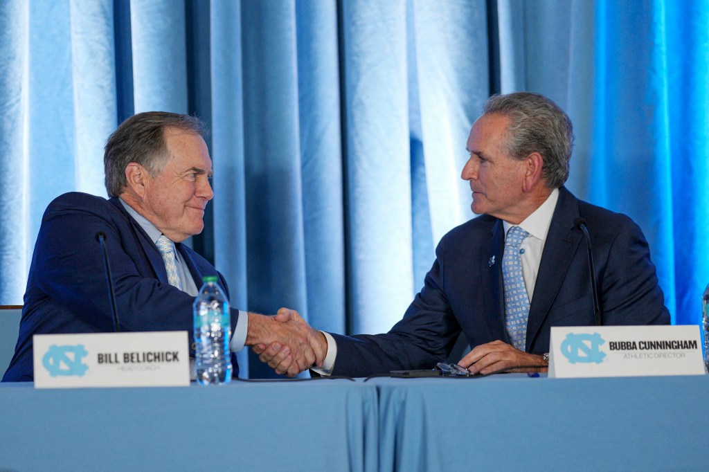 Tar Heels' new head coach Bill Belichick shakes hands with athletic director Bubba Cunningham at Loudermilk Center for Excellence. 