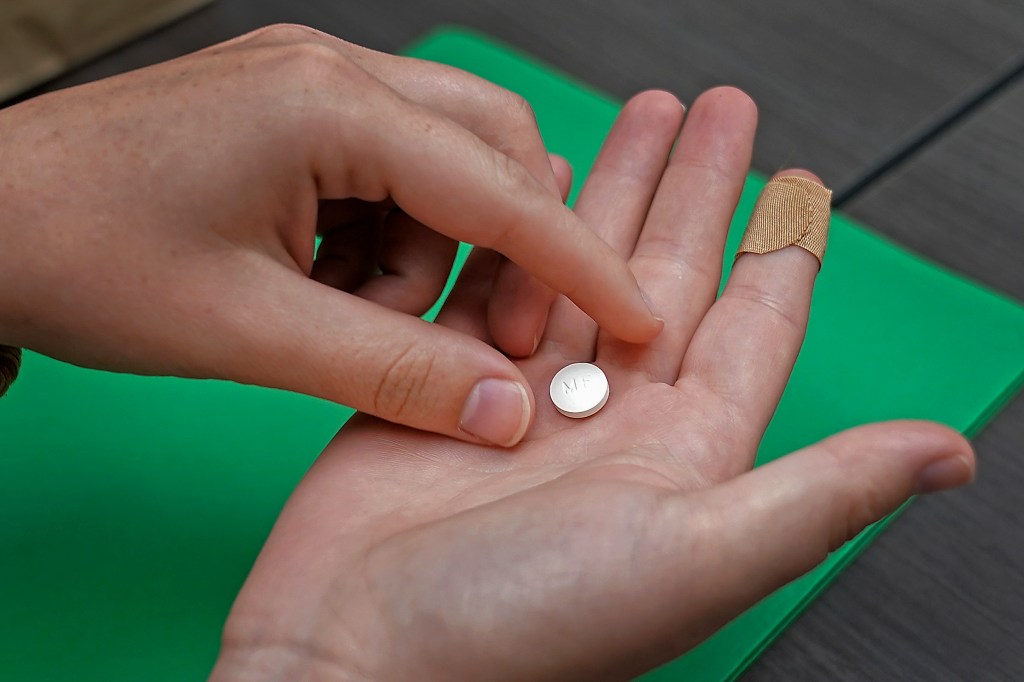 A patient preparing to take the first of two mifepristone pills for medication abortion at a clinic in Kansas City, Kan.