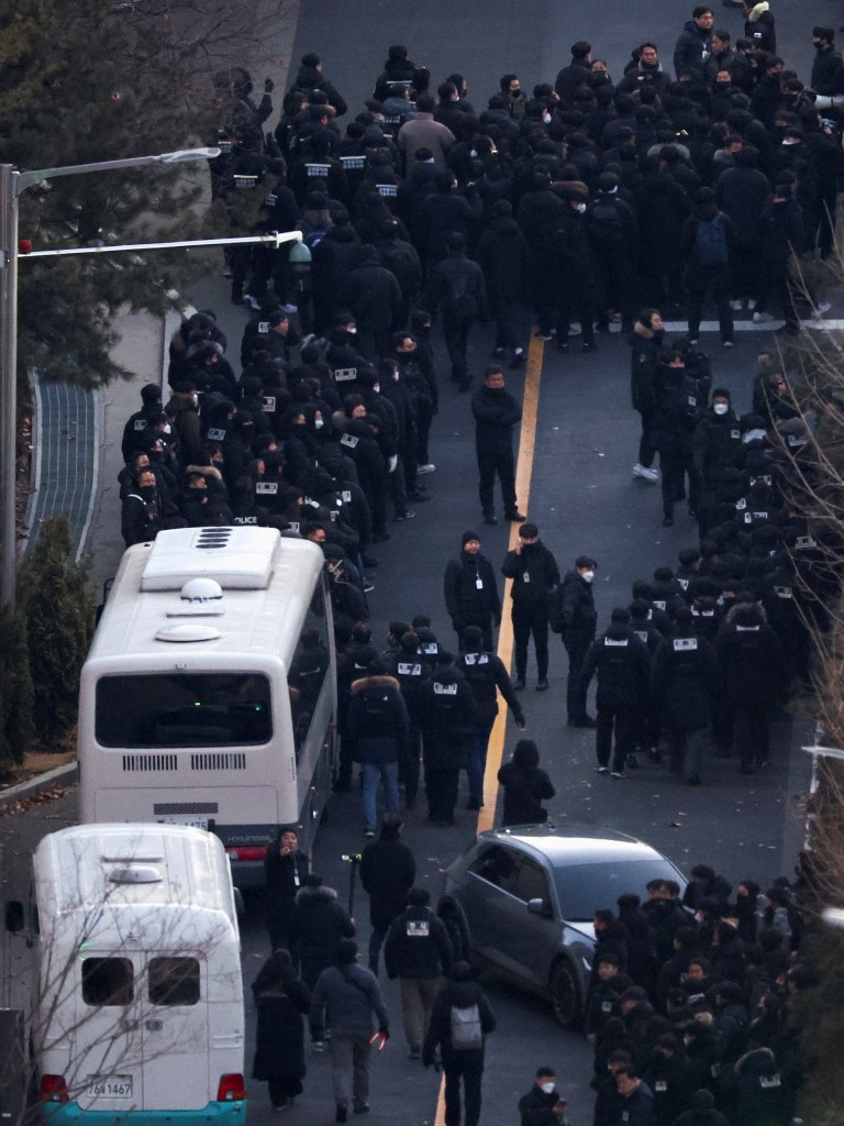 Police officers and investigators from Corruption Investigation Office entering impeached South Korean President Yoon Suk Yeol's residence to execute an arrest warrant.