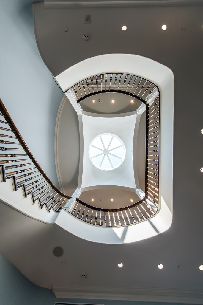 Originally built in the 1880s and fully gut-renovated, the home boasts luxury details like mahogany floors, Doric columns, dormer windows, an elevator, five gas fireplaces, and a spiral staircase with an oculus. 