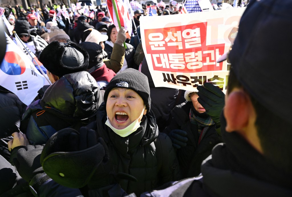 Supporters of impeached South Korean president Yoon Suk Yeol hold placards reading "We will fight with President Yoon Suk Yeol"