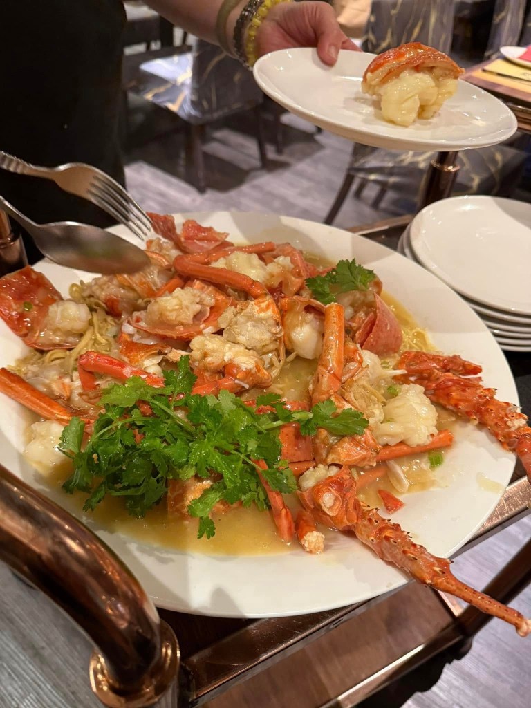 Woman looking upset at Canton Lane Chinese restaurant with a plate of seafood, including live lobster, on the table