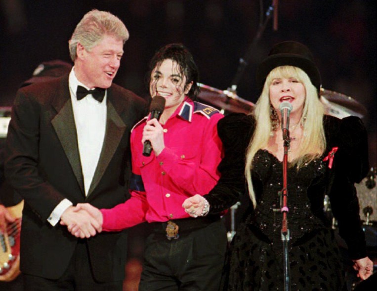 LANDOVER, UNITED STATES: US President Bill Clinton (L) shakes hands with singer Michael Jackson (C) as singer Stevie Nicks sings during inauguration festivities in Landover, Maryland. (Photo credit should read AFP/AFP/Getty Images)