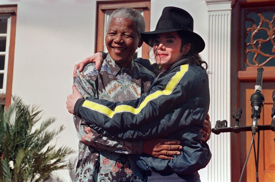 (FILES) US pop star and entertainer Michael Jackson (R) poses with Nobel Prize winner Nelson Mandela (L) in Kwazulu-Natal on July 20, 1996. Michael Jackson died on June 25, 2009 after suffering a cardiac arrest, sending shockwaves sweeping across the world and tributes pouring in on June 26 for the tortured music icon revered as the "King of Pop." AFP PHOTO/- (Photo credit should read -/AFP/Getty Images)