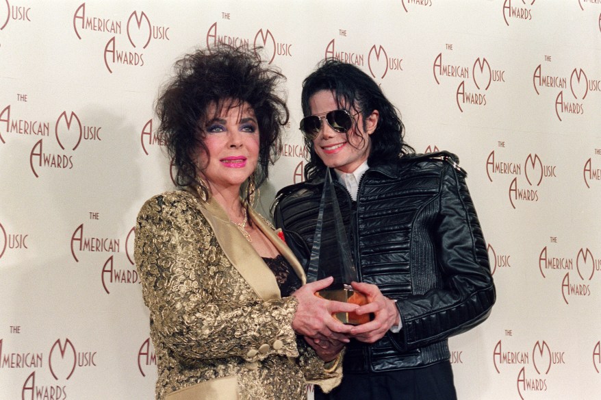 US Actress Elizabeth Taylor (L) with singer and performer Michael Jackson hold on one of two awards he won January 25, 1993 at the American Music Awards in Los Angeles. Michael Jackson died on June 25, 2009 after suffering a cardiac arrest, sending shockwaves sweeping across the world and tributes pouring in on June 26 for the tortured music icon revered as the "King of Pop." AFP PHOTO/Vince BUCCI (Photo credit should read VINCE BUCCI/AFP/Getty Images)