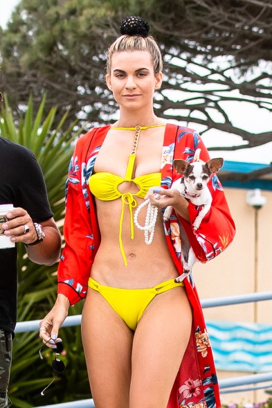 The social media star hit the beach in a neon yellow two-piece with a chain detail down the center that connects to a choker.