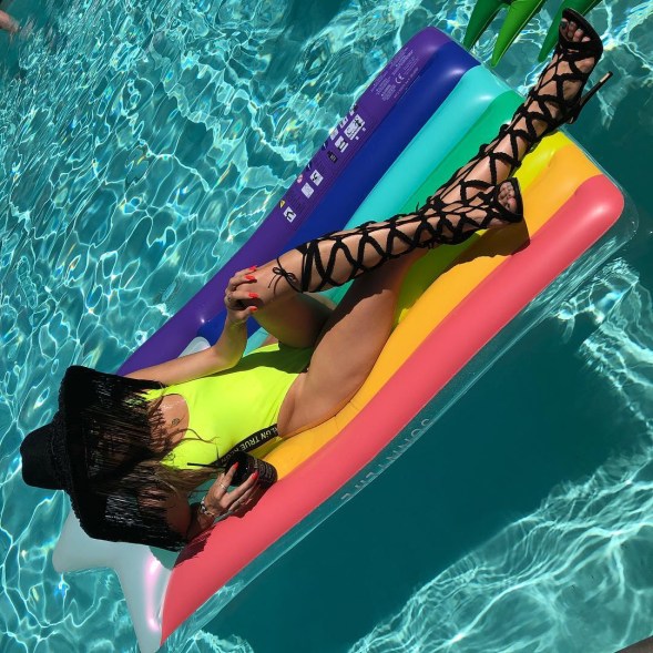 McCord also has her fair share of full-coverage swimwear, but she balances out all that fabric by amping up the accessories. In this case, the blogger lounged on a rainbow floaty in her neon green True Religion bodysuit ($99) while wearing a black hat trimmed in face-obscuring fringe and knee-high, lace-up stiletto heels by Just Fab.