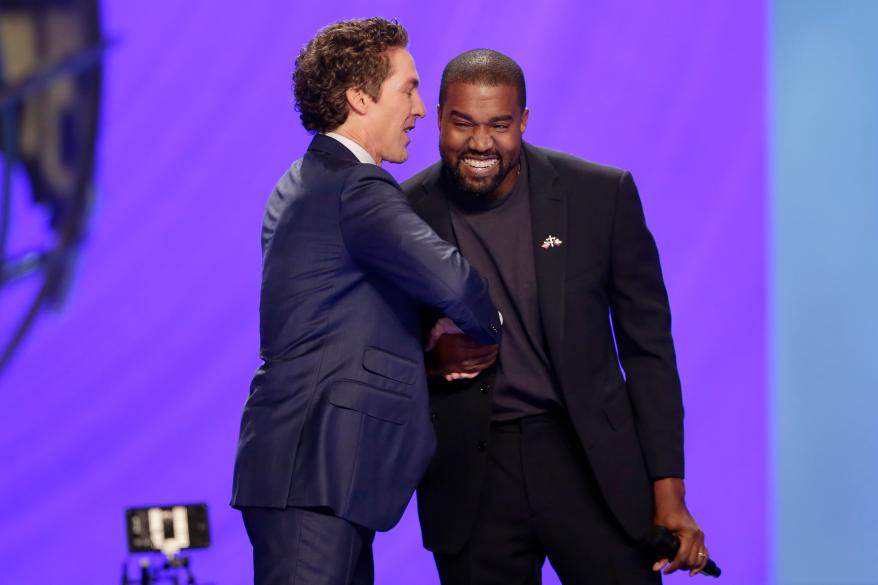 Rapper Kanye West, right, shakes hands with Pastor Joel Osteen