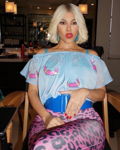 Kourtney Kardashian sitting in a makeup chair in her "True Romance" Halloween costume