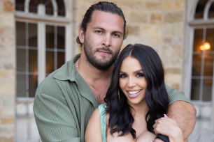 Brock Davies hugs Scheana Shay from behind.