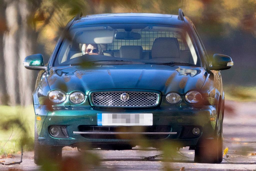 Queen Elizabeth II driving her Jaguar car on the grounds of Windsor Castle after a stress-induced health scare.