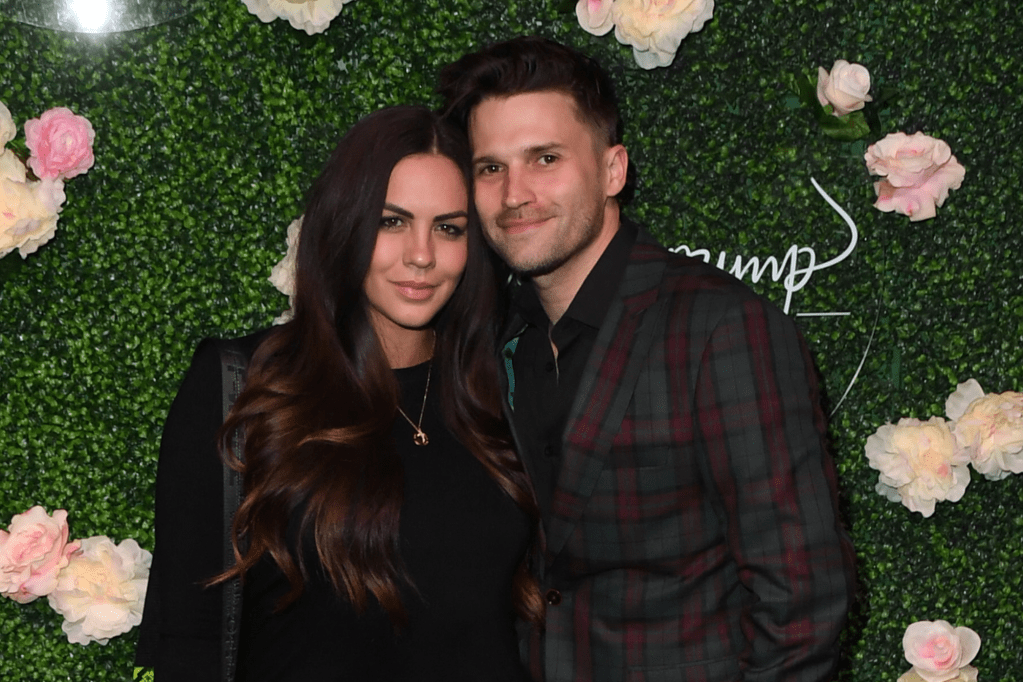 Katie Maloney and Tom Schwartz posing together at the grand opening of Vanderpump Cocktail Garden in Las Vegas.