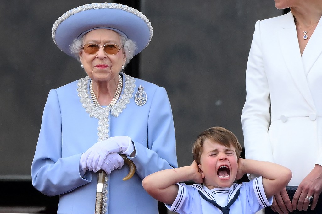 Queen Elizabeth II standing next to Prince Louis as he covers his ears at the Trooping the Colour parade.