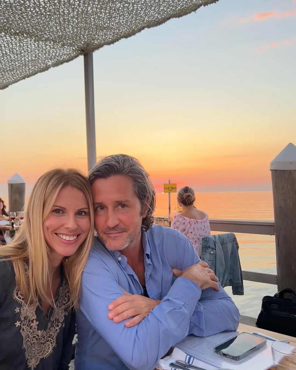 Petra Kashoggi and Danny Baker Jr. pose together in front of the ocean