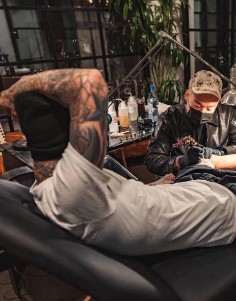 Dr. Woo tattooing Travis Barker