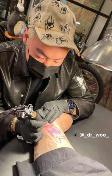 Dr. Woo tattooing Travis Barker