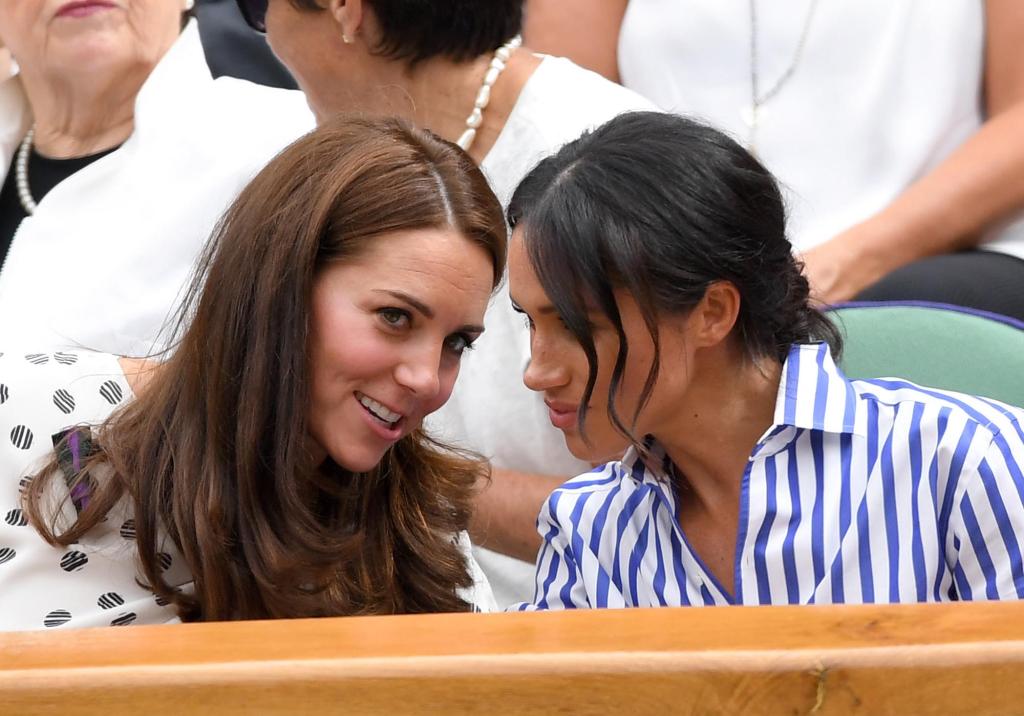 Kate Middleton and Meghan Markle talking at an event.