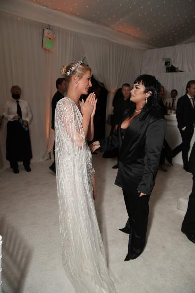 Paris Hilton and Demi Lovato standing and talking at Hilton's wedding.