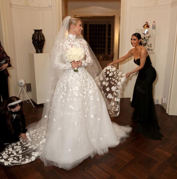 Kim Kardashian fixing Paris Hilton's wedding veil.