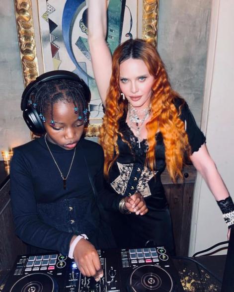 Madonna strikes a pose behind turntables with one of her twin daughters