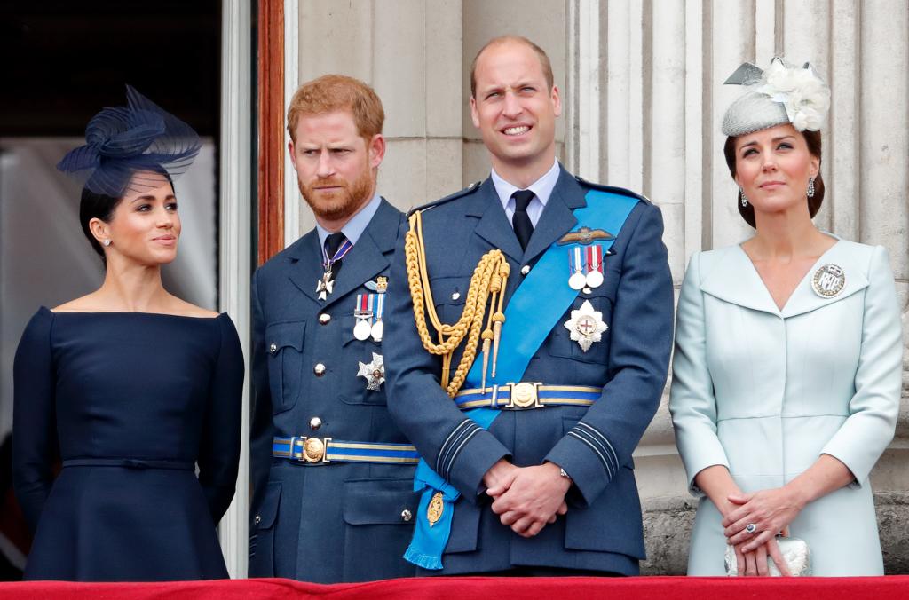 Meghan Markle, Prince Harry, Prince William and Kate Middleton standing on a balcony