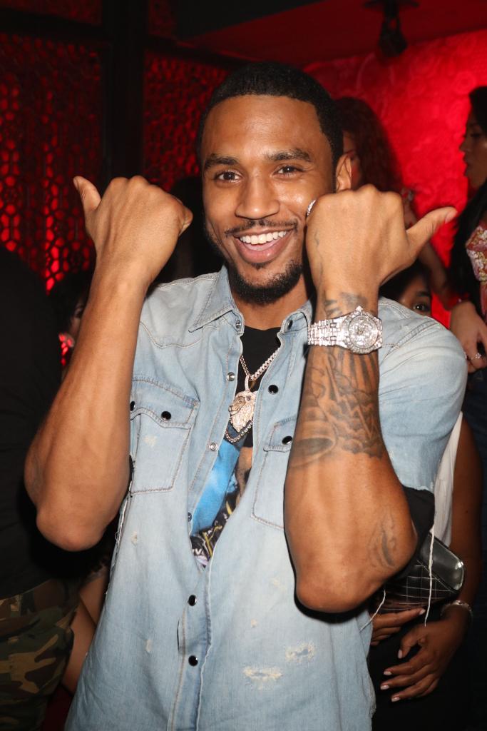 Trey Songz smiling and pulling his arms up.