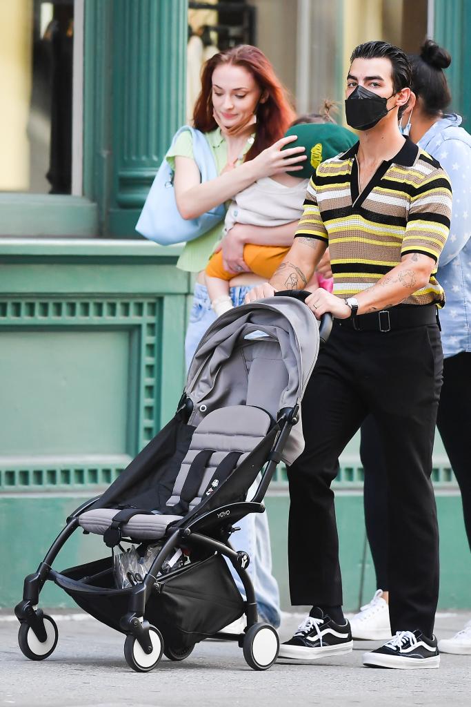 Sophie Turner and Joe Jonas walking with their kid.