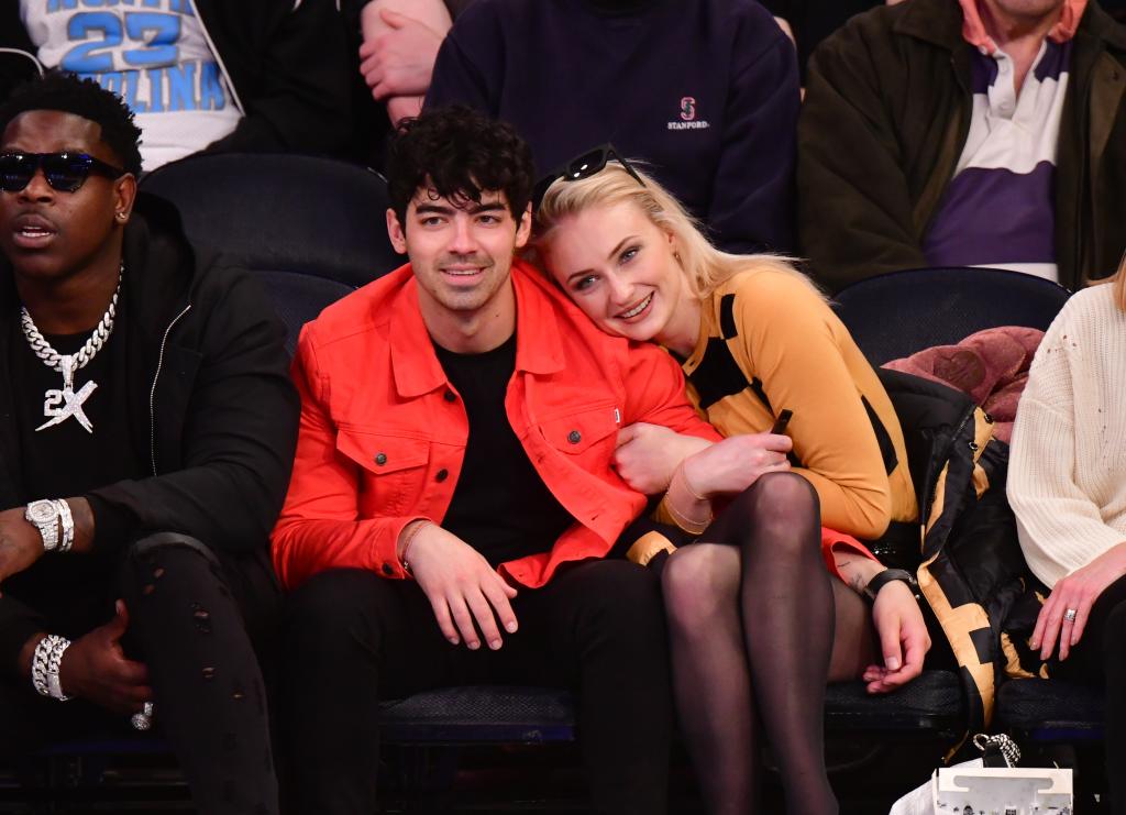 Joe Jonas and Sophie Turner sitting courtside at an NBA game.