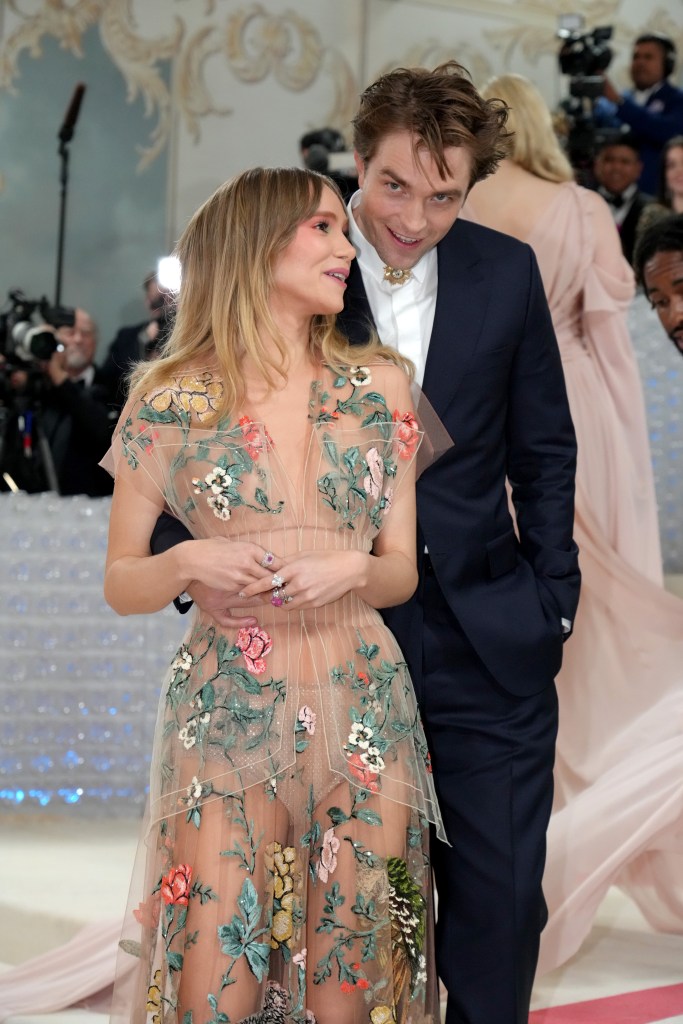 Suki Waterhouse and Robert Pattinson on a red carpet.