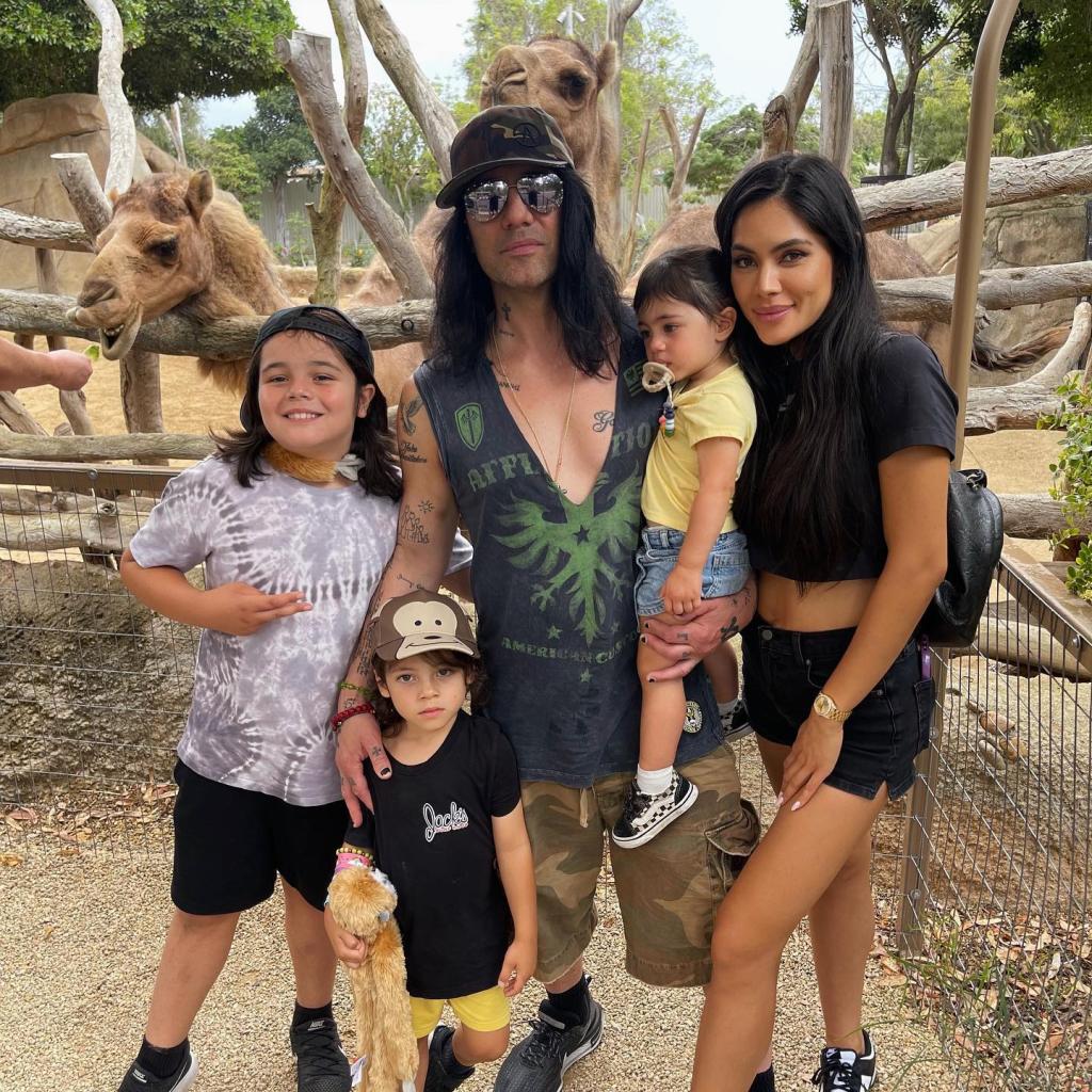 Criss Angel and Shaunyl Benson posing with their three kids