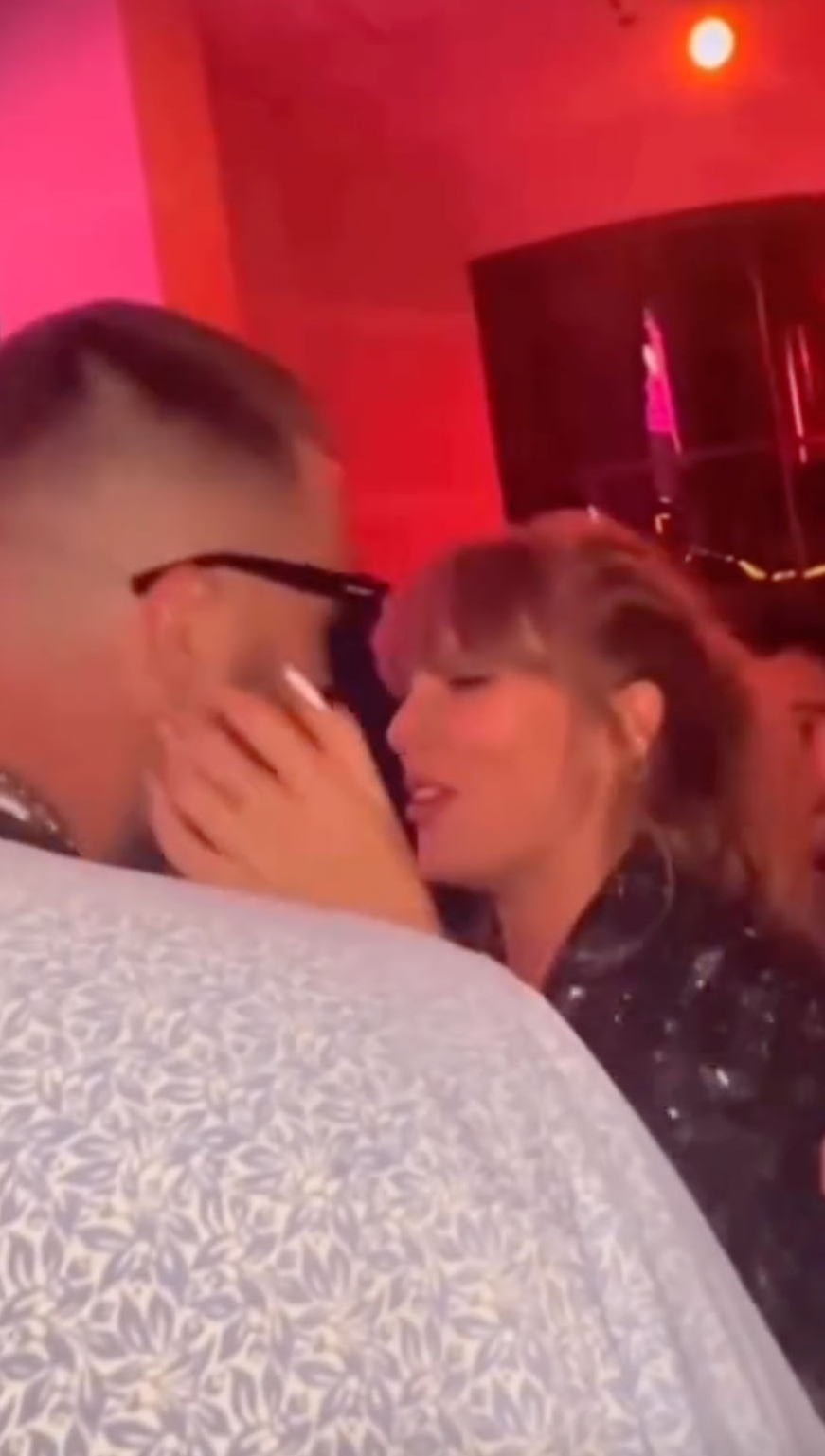 taylor swift with her hands on travis kelce's face