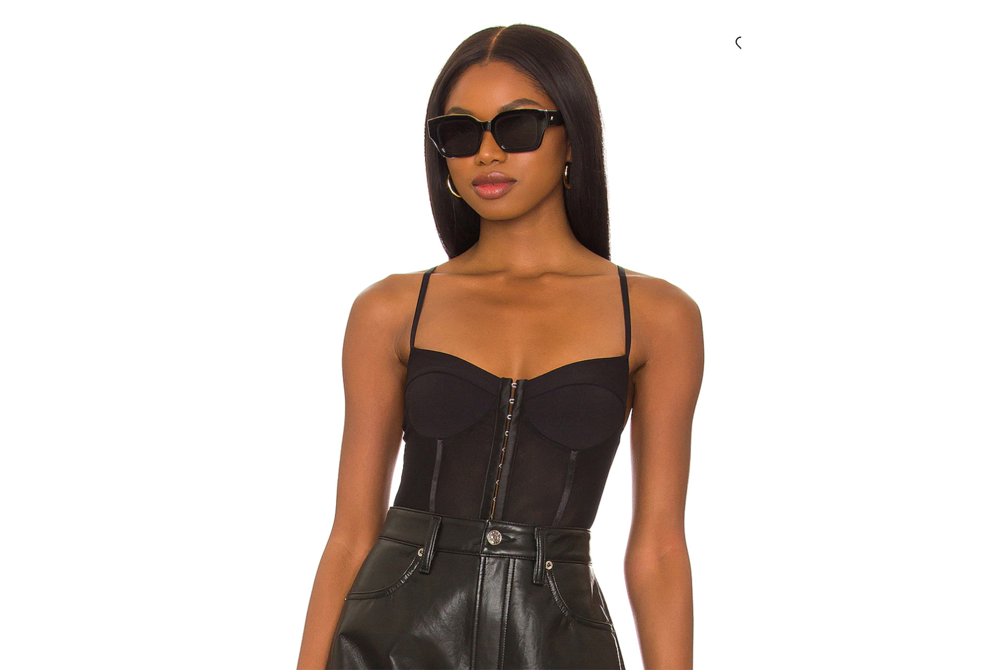 A model in a black corset top and leather shorts