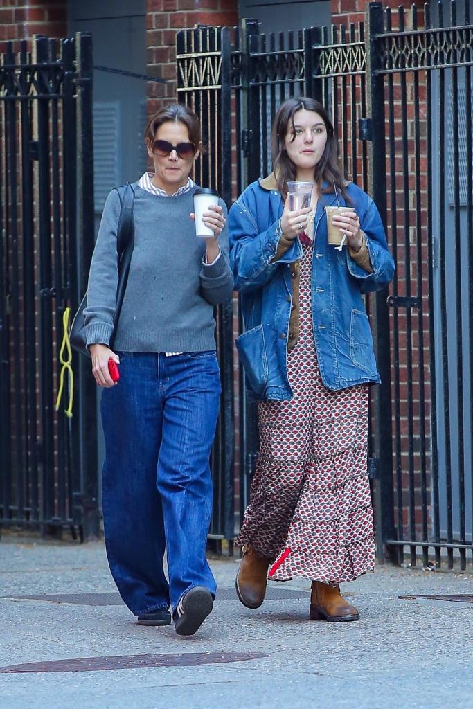 Katie Holmes and Suri Cruise walking with coffee in New York City. 