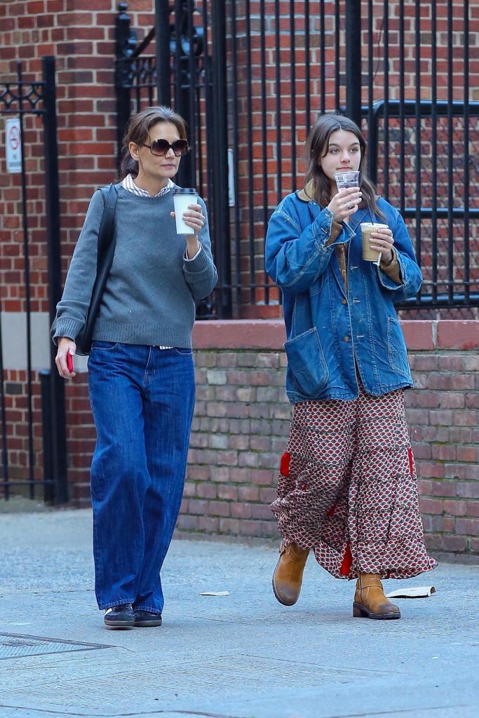 Katie Holmes and Suri Cruise walking with coffee in New York City. 