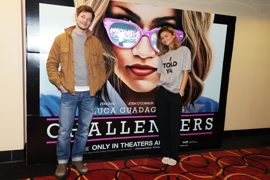 zendaya and mike faist posing in front of "challengers" poster