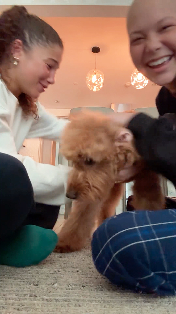 Isabella and Sophia Strahan playing with their dog.