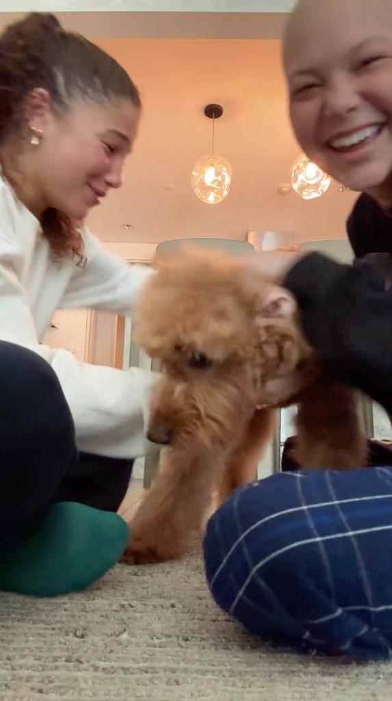 Isabella and Sophia Strahan playing with their dog.